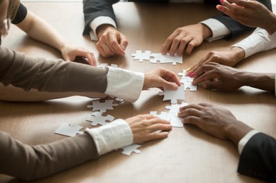 Teamwork-Puzzle Many hands solving a puzzle