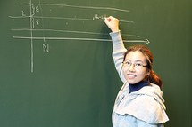young female researcher in front of blackboard