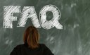 Person standing in front of a blackboard with letterd FAQ written on it